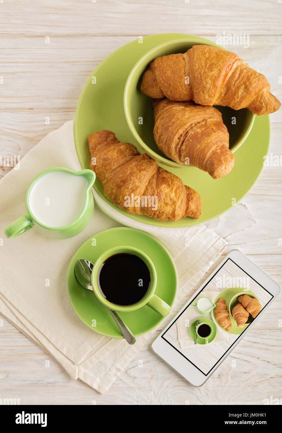 Kaffee mit Milch, Croissants und Smartphone mit Foto. Selektiven Fokus. Stockfoto
