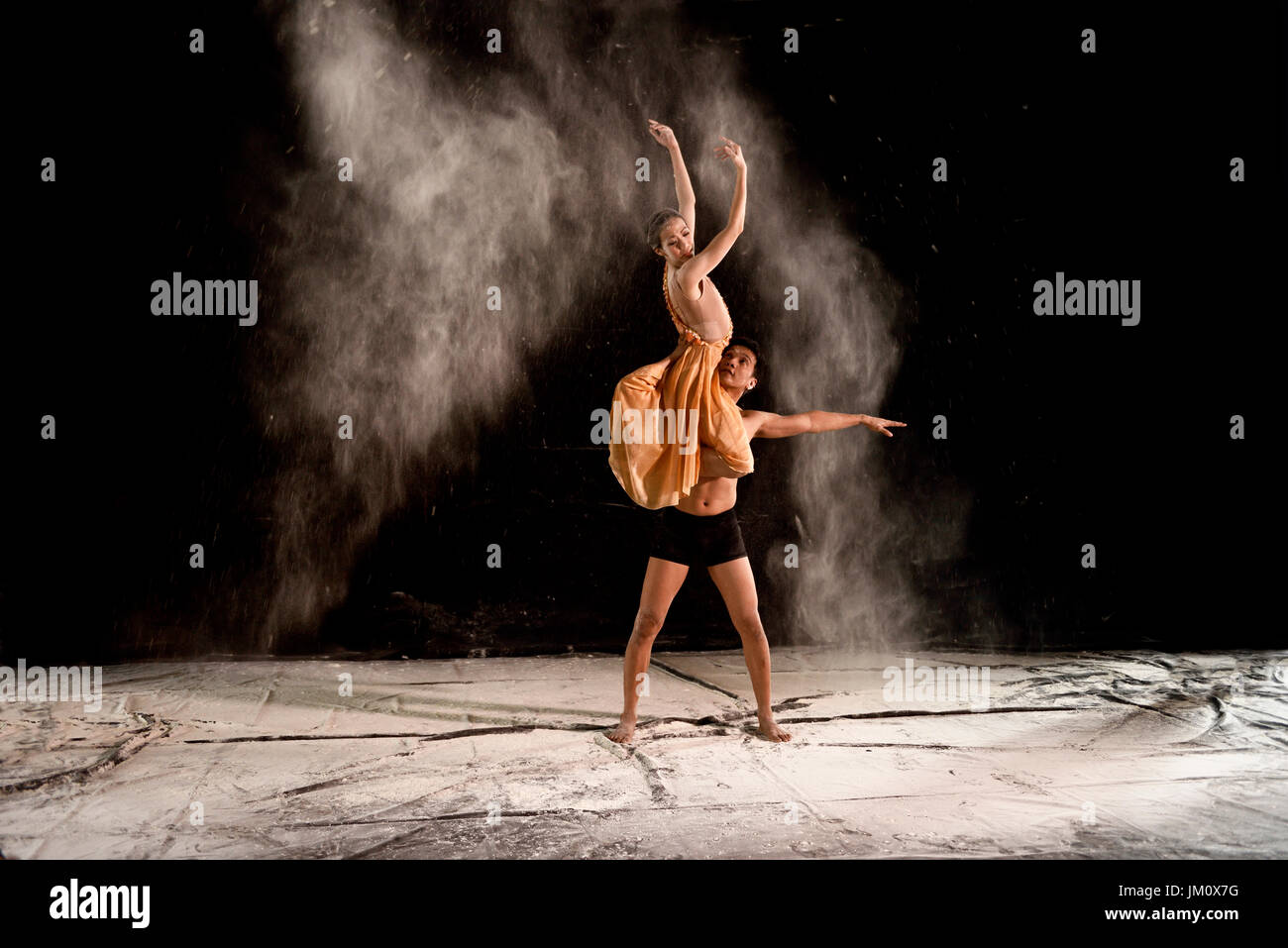 Junges Paar Ballett mit Pulver in der Phase vor schwarzem Hintergrund Stockfoto