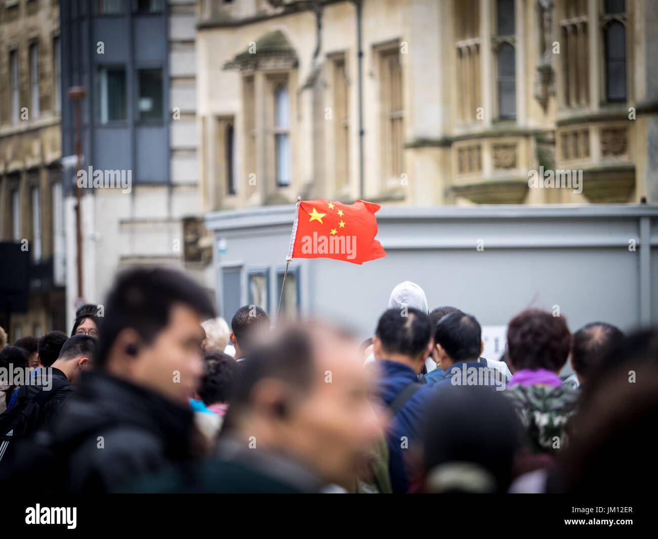 Chinesische Touristen Cambridge - Parteien der chinesischen Touristen mit Guide mit Kennzeichnung Flagge im historischen Zentrum von CAMBRDIGE UK Stockfoto