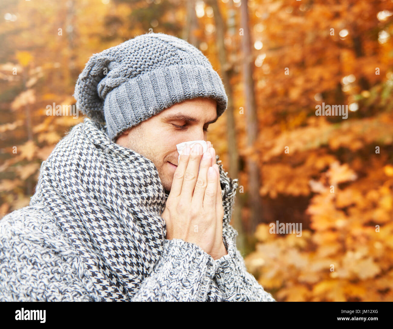 Kranker Mann seine Nase weht Stockfoto