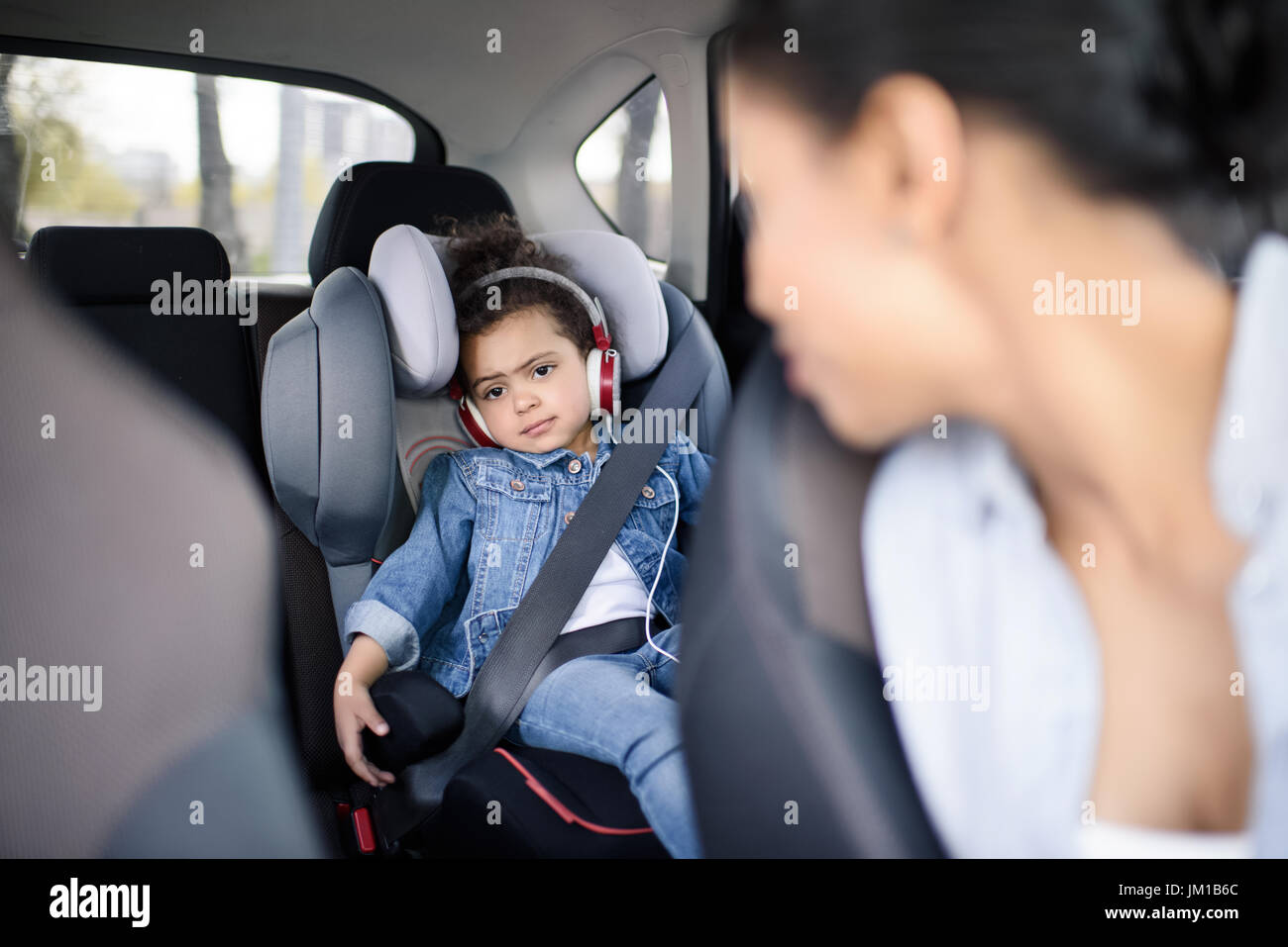 kleine Mädchen hören von Musik im Kopfhörer während der Fahrt im Auto  Stockfotografie - Alamy