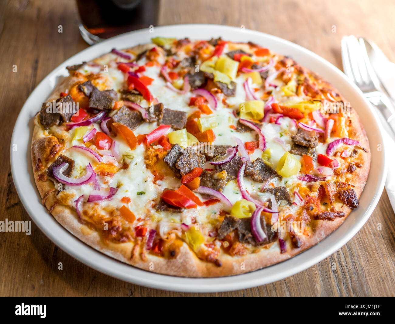 Köstliche frische Kebab Pizza Abendessen auf Platte auf Holztisch Stockfoto