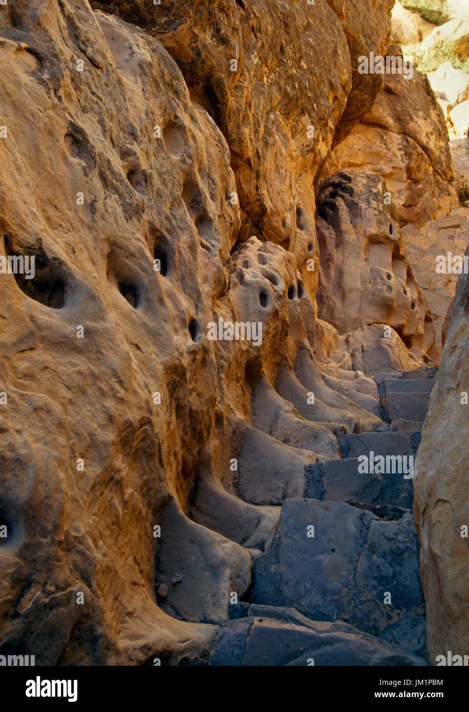 Acoma Pueblo, Zuschüsse, New Mexico, USA; Alten Trail Felsen. Moderne Schritte neben Fels gehauenen Hand und Fuß hat. Stockfoto