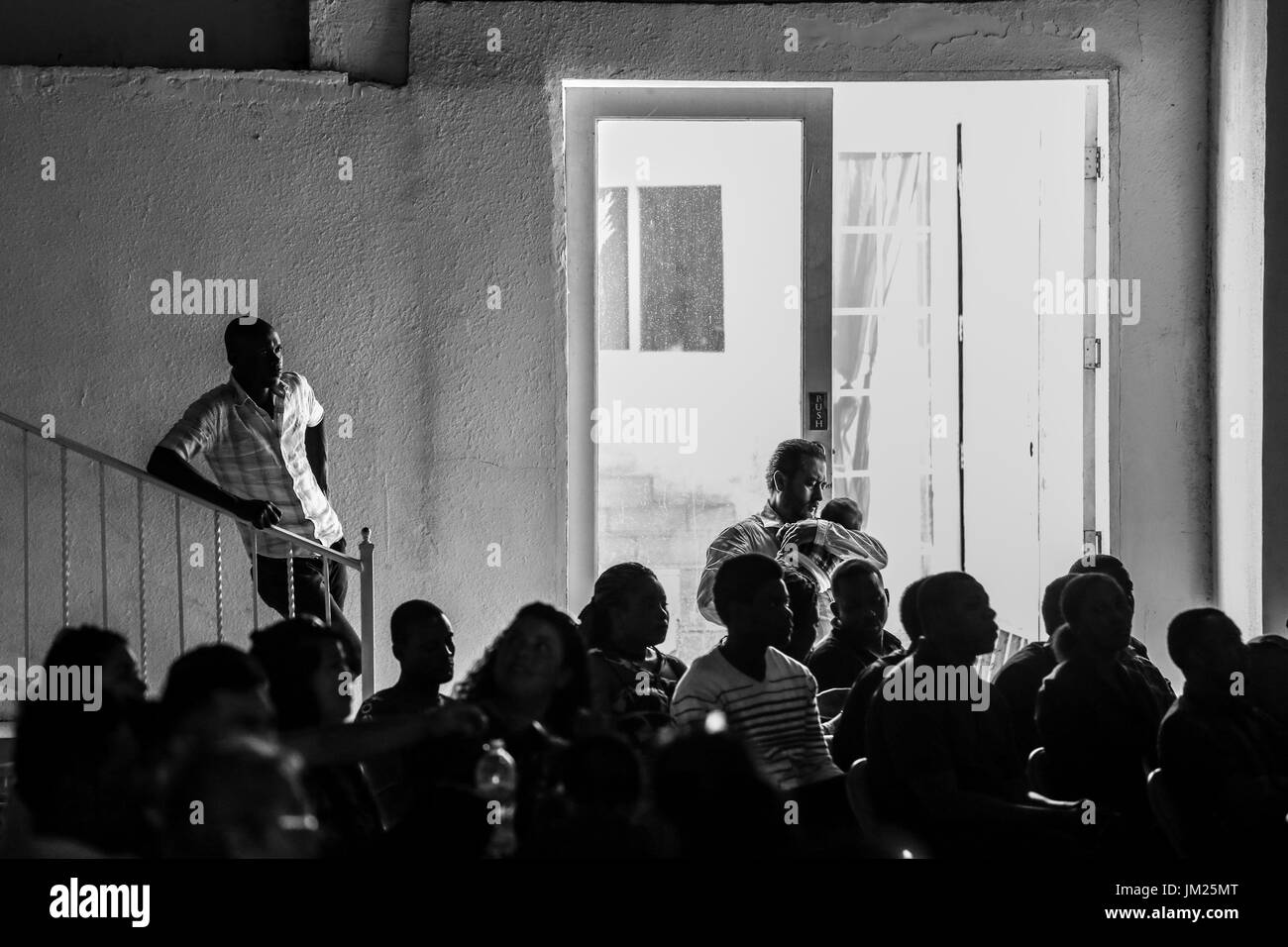 Tijuana, Baja California, Mexiko. 2. Juli 2017. Eine haitianische Migranten (links) und mexikanische Mann und Kind (rechts) während einer Hochzeit für zwei mexikanischen Paare bei der Iglesia Evangelica Embajadores de Jesus in Tijuana, Baja California zu sammeln. Die Kirche wurde in ein Tierheim für den Zustrom von haitianischen Migranten umgewandelt, die sich fest in Mexiko, nachdem ihre Hoffnungen der Überfahrt in die Vereinigten Staaten als Folge der Einwanderungspolitik gestoppt wurden gefunden. Bildnachweis: Joel Angel Juarez/ZUMA Draht/Alamy Live-Nachrichten Stockfoto