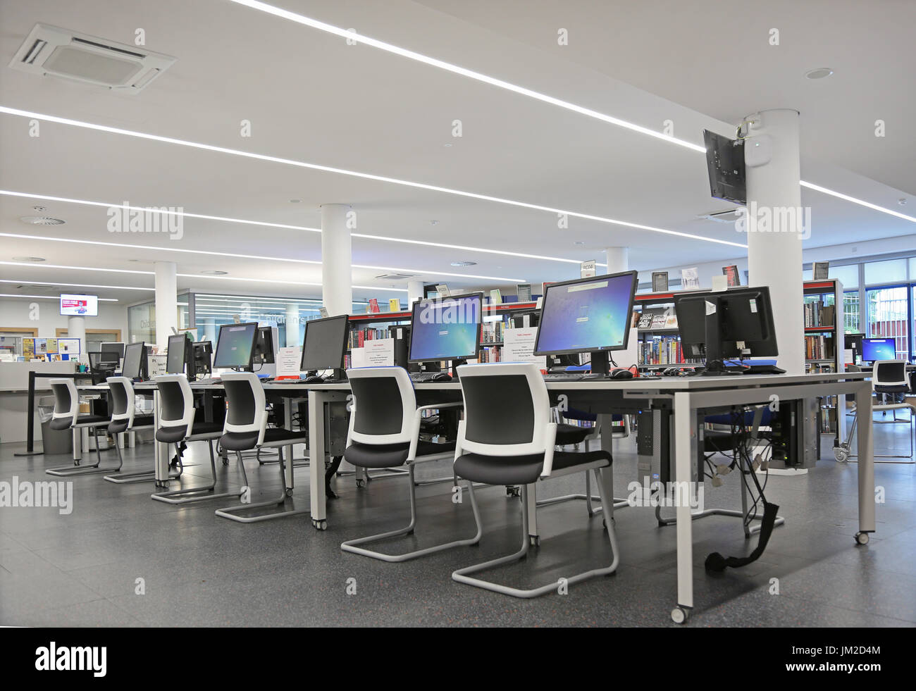 Computerbereich in der neu umgebauten Marcus Garvey Bibliothek in London Borough of Haringey, Vereinigtes Königreich. Zeigt traditionelle Bücherregale und neue Computer-Terminals. Stockfoto