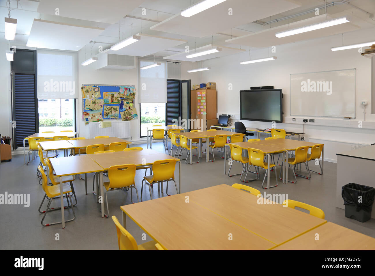 Innenraum eines Klassenzimmers in einer neu errichteten Grundschule im Osten Londons, Großbritannien. Zeigt Schreibtische, Stühle und großen TV-Bildschirm.leer, keine Schüler. Stockfoto