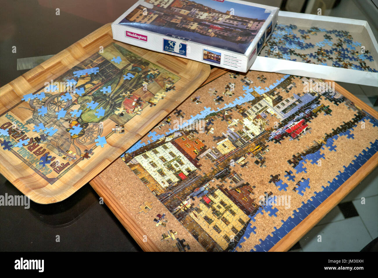 Teilweise abgeschlossen Puzzle mit einigen Stücken, die Verlegung in ein Fach warten auf Auswahl. Stockfoto