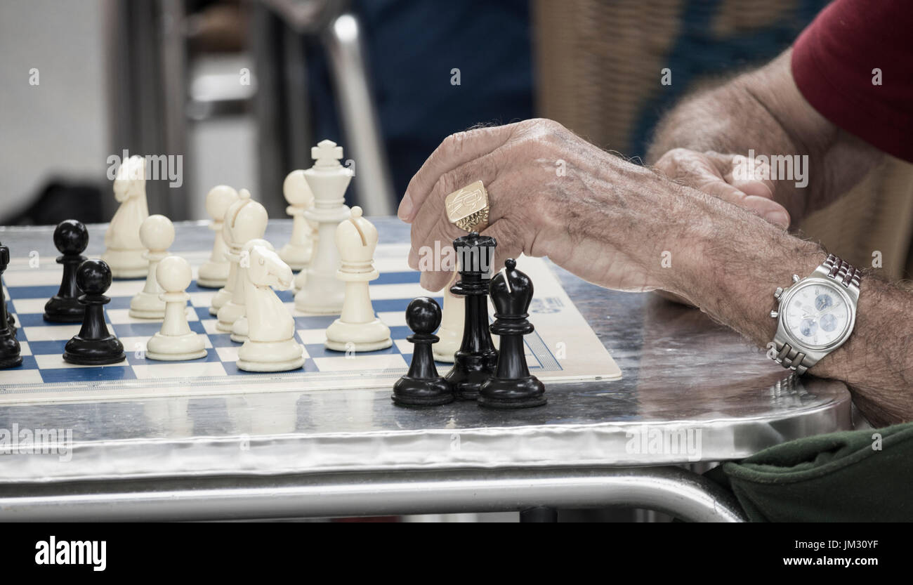 Die älteren spanischen Männer Schach spielen im Freien in Park Stockfoto