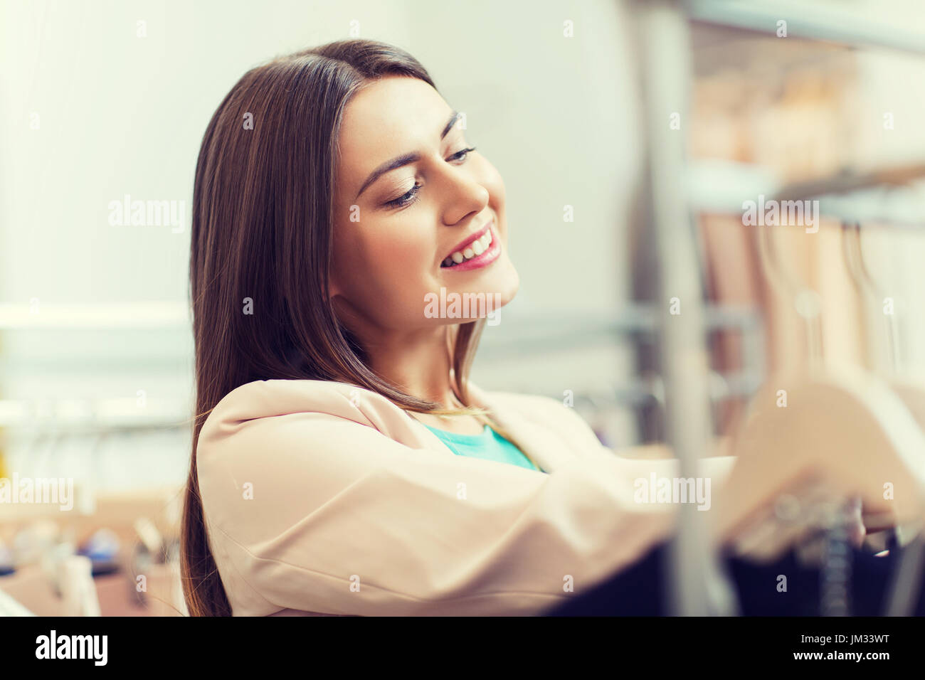 glückliche junge Frau, die Wahl der Kleidung in der mall Stockfoto