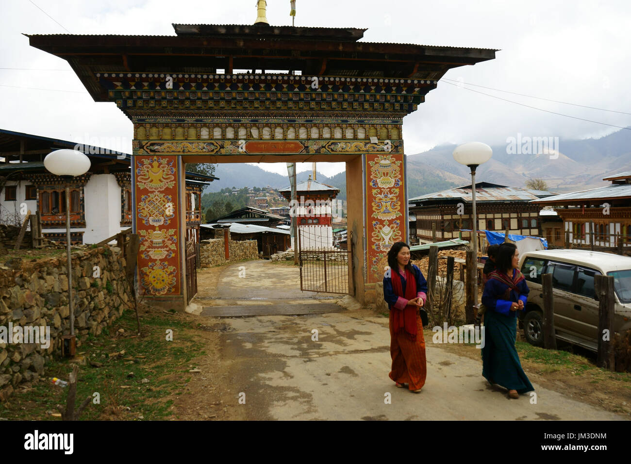 Frauen in traditioneller Kleidung gehen im freien Tor zum Land Kloster, Phobjikha Tal Bhutan Stockfoto
