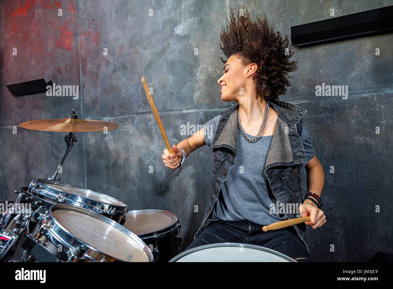 Porträt von emotionalen Frau spielt Schlagzeug in Studio Drummer Rock Konzept Stockfoto