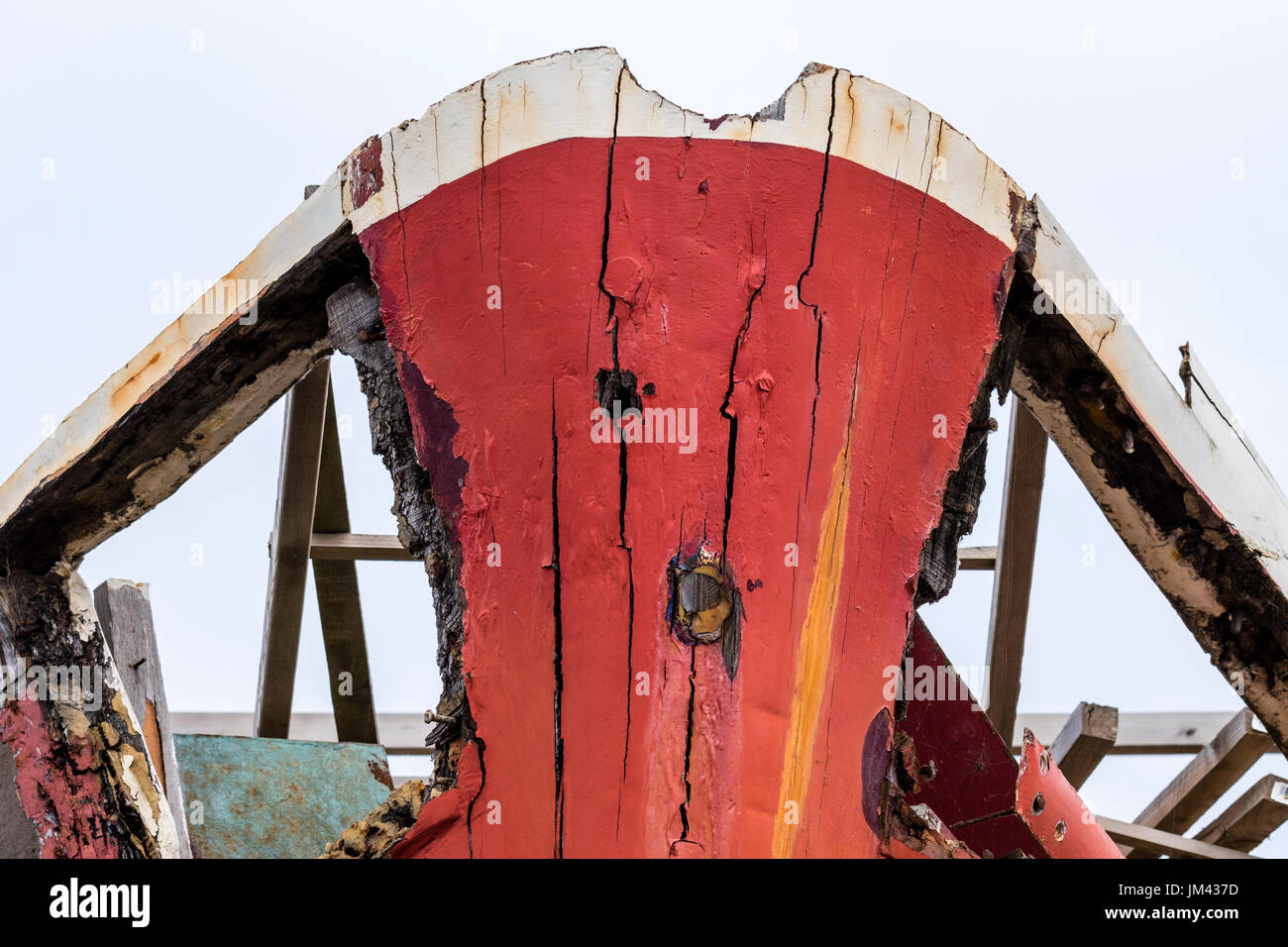 Matt rot bemalten Bögen der alten Trocken - angedockt Boot. Holzarbeiten bröckelt mit Alter und Verwitterung Stockfoto