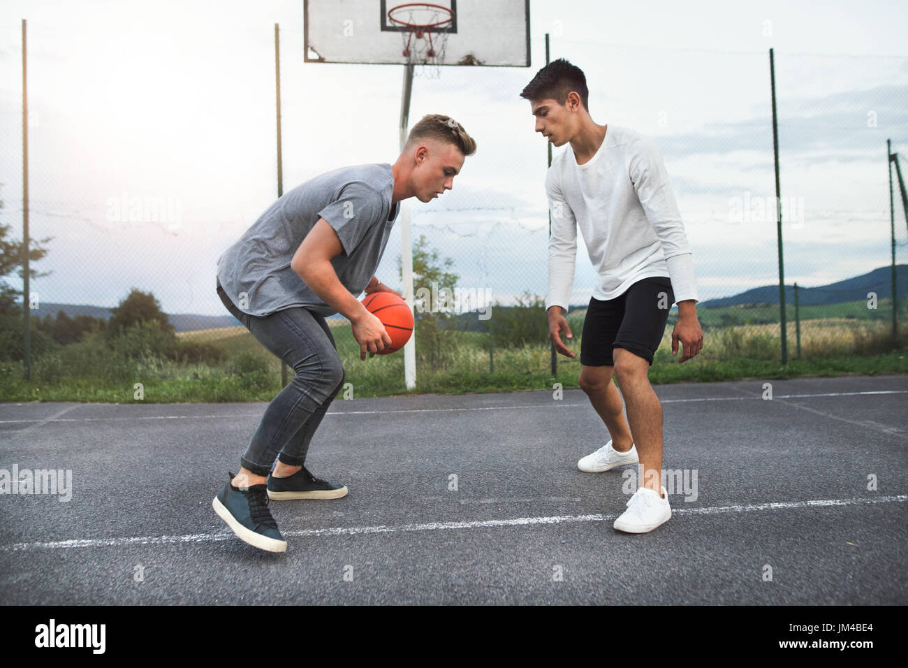 Zwei hübsche Jungs im Teenageralter Basketball auf Spielplatz im Freien spielen. Stockfoto