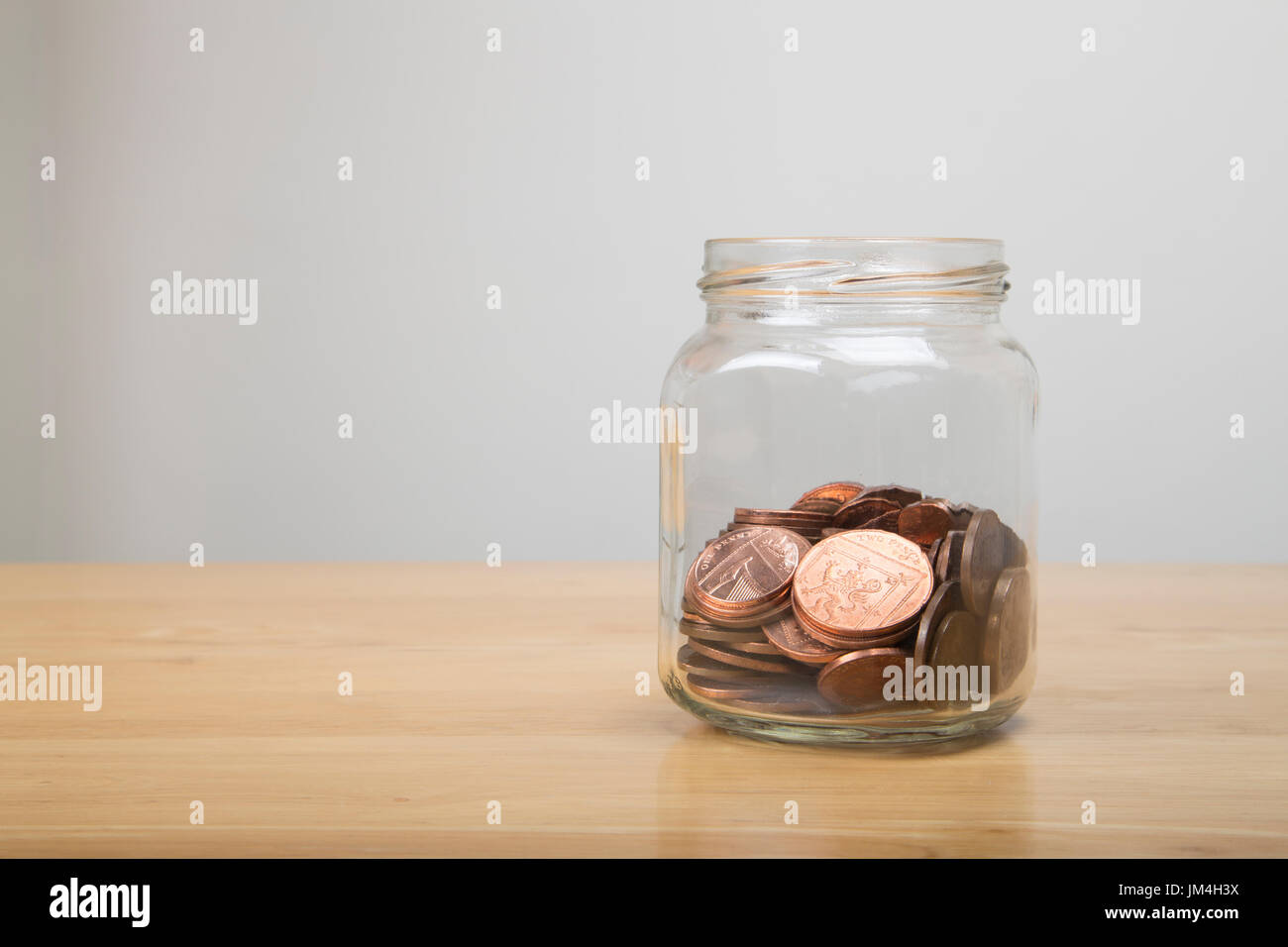 Glas mit niedrigen Wert britischen Münzen innerhalb Stockfoto