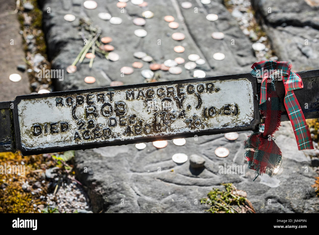 Münzen auf dem Grab des Rob Roy MacGregor an der Balquhidder Kirkyard, Stirling, Schottland, UK Stockfoto