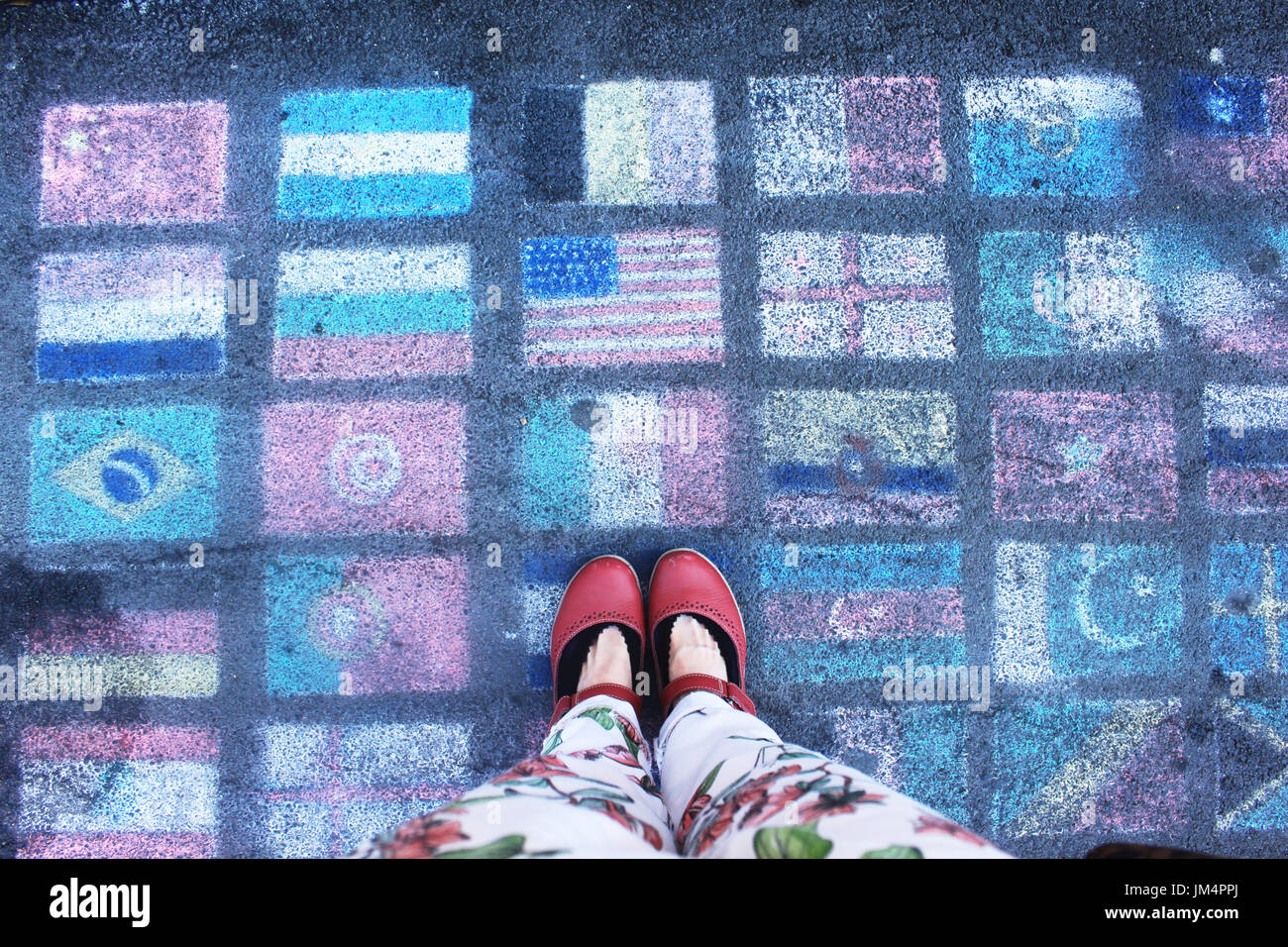 Ein Fernweh stehen auf der Straße Malerei von verschiedenen Länderflaggen. Stockfoto