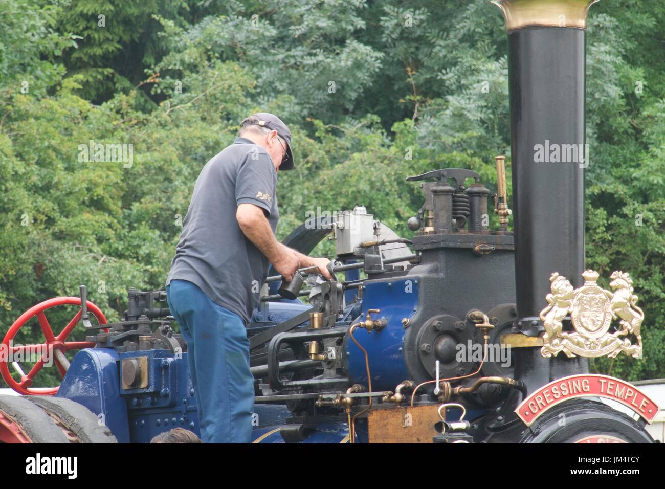 Mann, die Wartungsarbeiten auf Zugmaschine in Masham Steam Fair, Masham, North Yorkshire, UK Stockfoto
