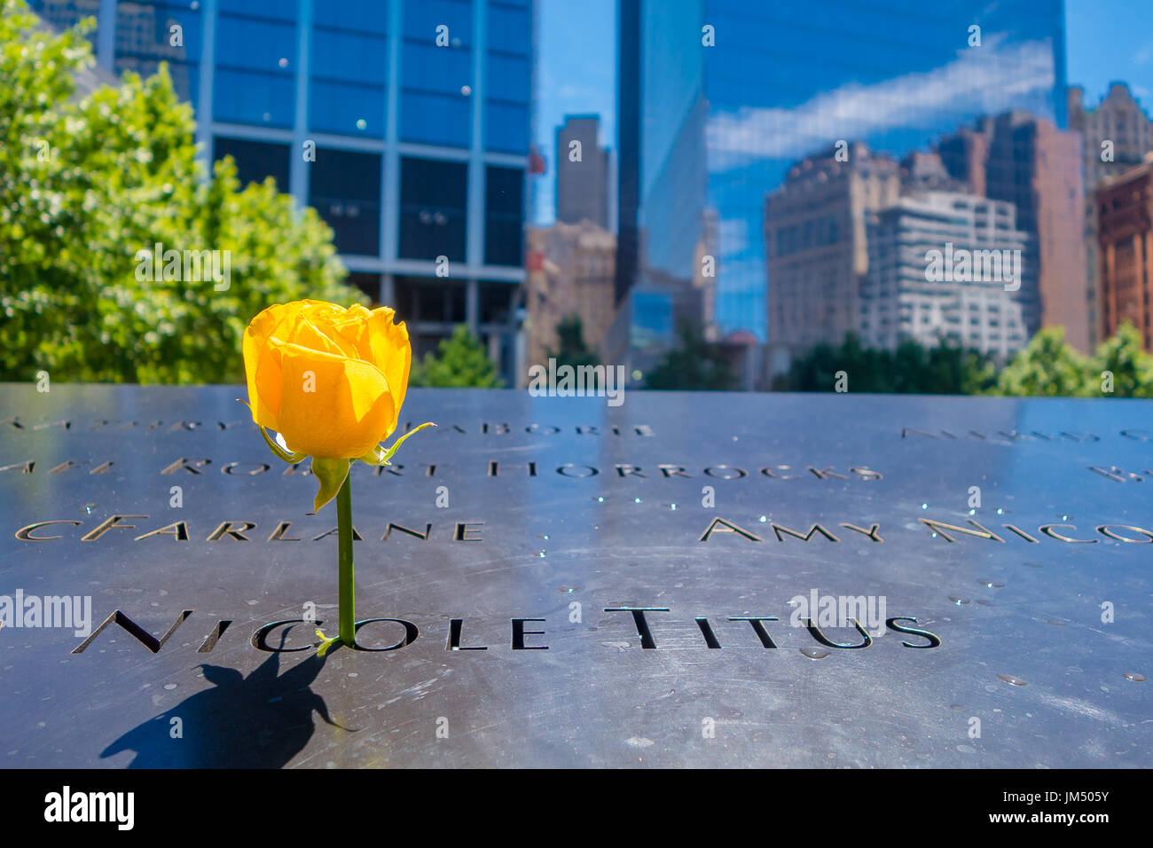 NEW YORK, USA – 5. Mai 2017: Gelbe Blüte im Inneren einen Fußabdruck Namen auf 911 Memorial World Trade Center in New York Usa Stockfoto