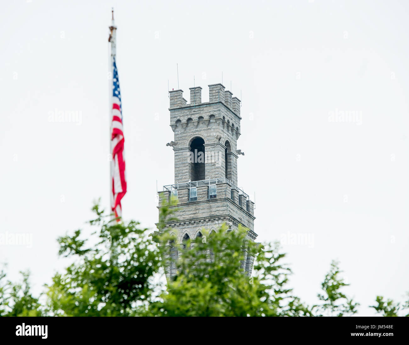 Nach oben Stein Pilgrim Monument mit amerikanischer Flagge und Baumkronen schließen bis weissen Himmel im Hintergrund in Provincetown PTown P-Town Cape Cod MA Stockfoto Nach oben Stein Pilgrim Monument mit amerikanischer Flagge und Baumkronen schließen bis weissen Himmel im Hintergrund in Provincetown PTown P-Town Cape Cod MA Stockfoto