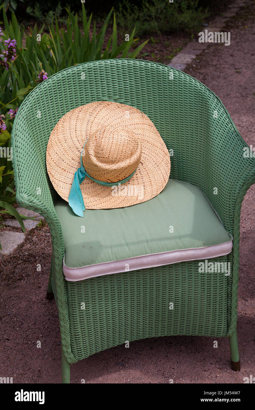 Damen Strohhut auf Korbstuhl Stockfoto