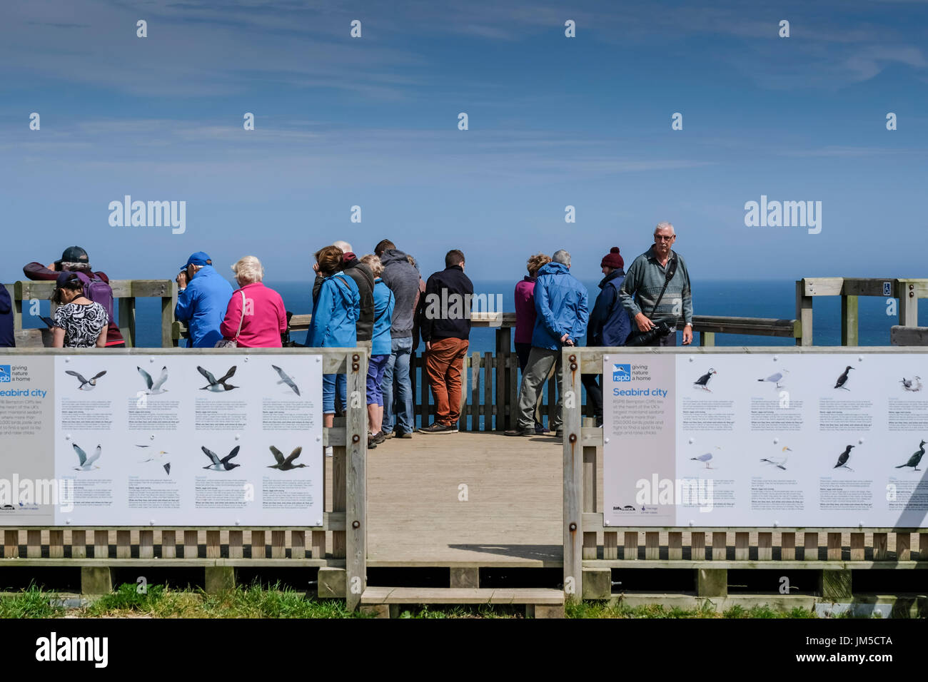 Eine Gruppe von Naturliebhaber auf einem Bempton Cliffs Aussichtspunkt auf der RSPB Natur Reserve, UK. Männer und Frauen, Männer und Frauen. Stockfoto