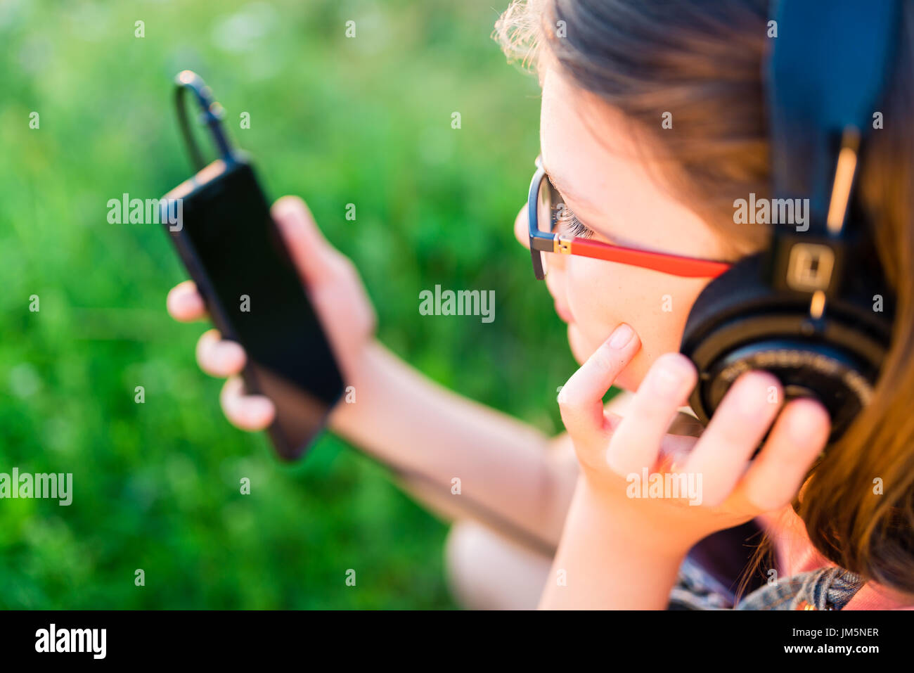 Teengirl Musikhören mit ihrem retro Vintage Kopfhörer im freien Stockfoto