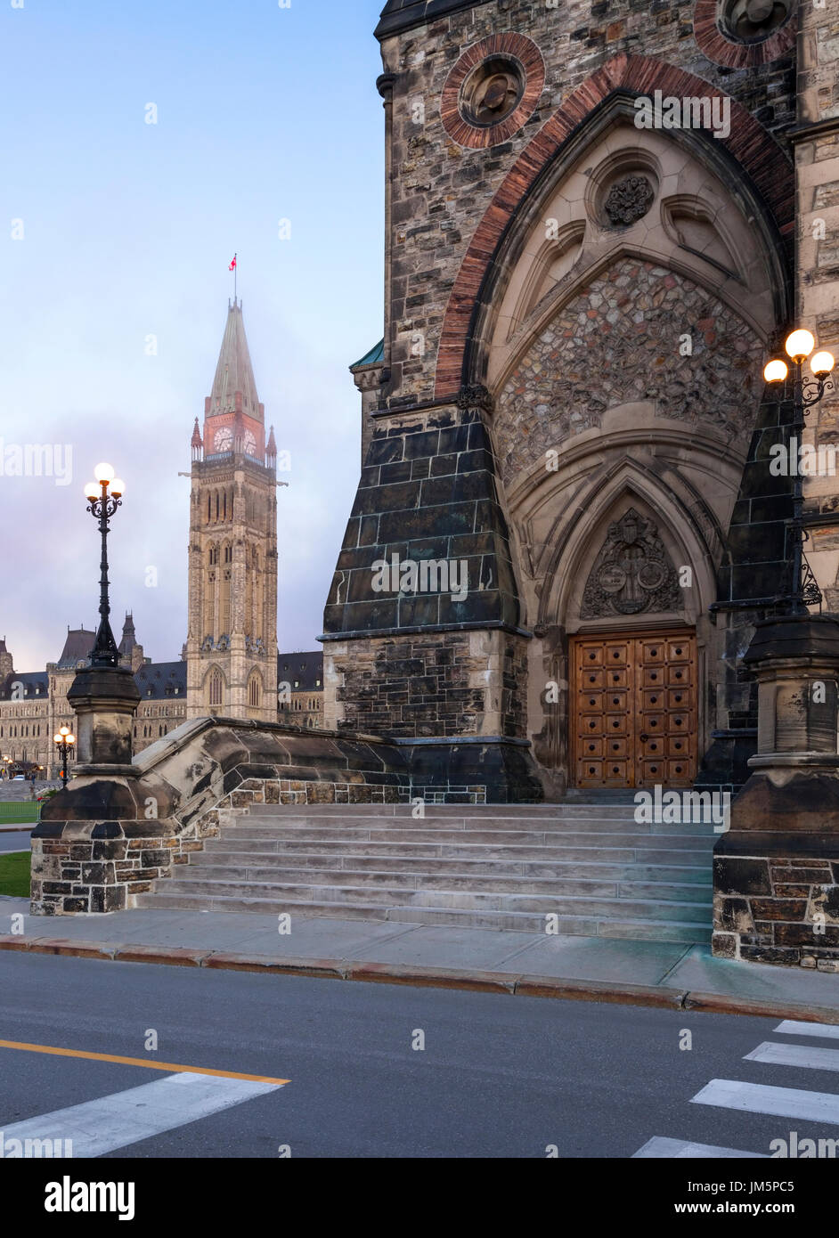 Die West-Block, der Teil des Parliament Hill mit der Peace Tower und Centre Block im Hintergrund ist von der aufgehenden Morgensonne in Ottawa beleuchtet. Stockfoto