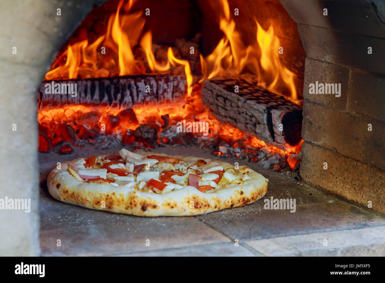 Flammenden Holzofen heißen Pizza backen im Ofen Stockfoto