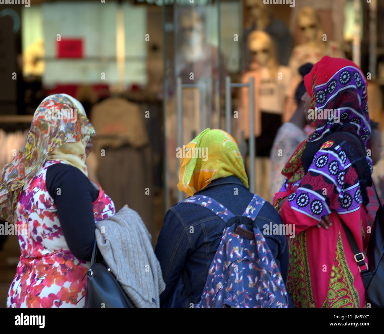 Wetter im Sommer kehrt zurück und genießen Sie den Sommer in der Stadt vor westliche Kleidung Shop, einheimischen und afrikanischen traditionell gekleidet Stockfoto