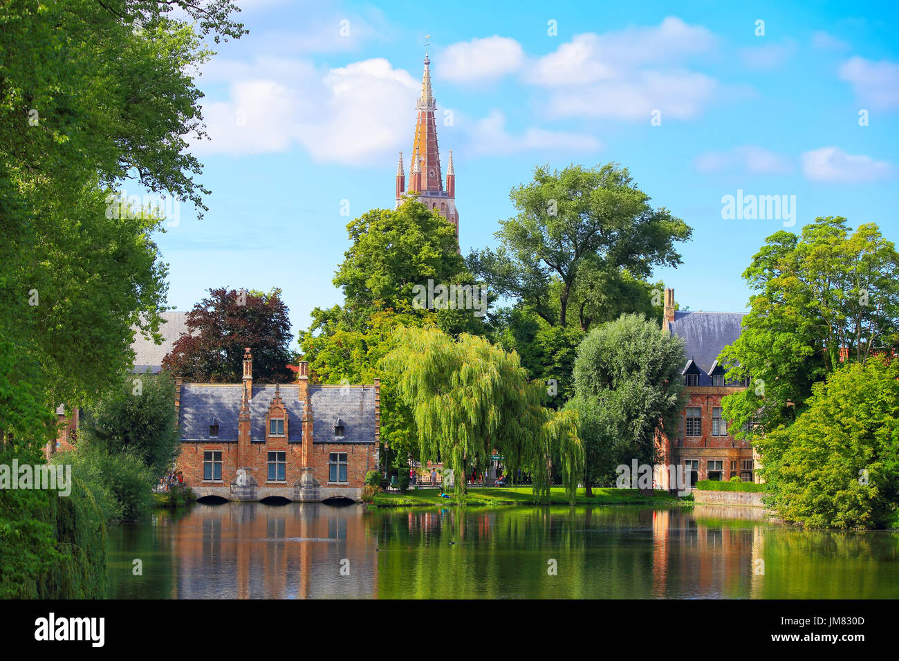 Stadtbild von Brügge an einem Sommertag. Altbauten und grüne Bäume auf einen Wasserkanal in Brügge. Stockfoto