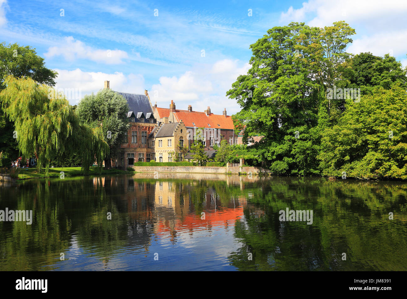 Stadtansicht von Brügge. Brügge Attraktionen im Grün der Bäume spiegelt sich im Wasser. Sonnigen Sommertag in Brügge. Stockfoto