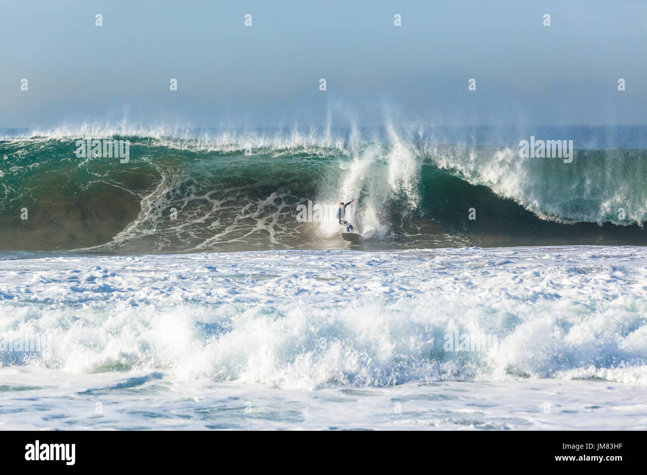 Surfer Surfen ausziehen fallenden auszulöschen Fahrt auf großen hohlen Ozeanwelle abstürzt. Stockfoto