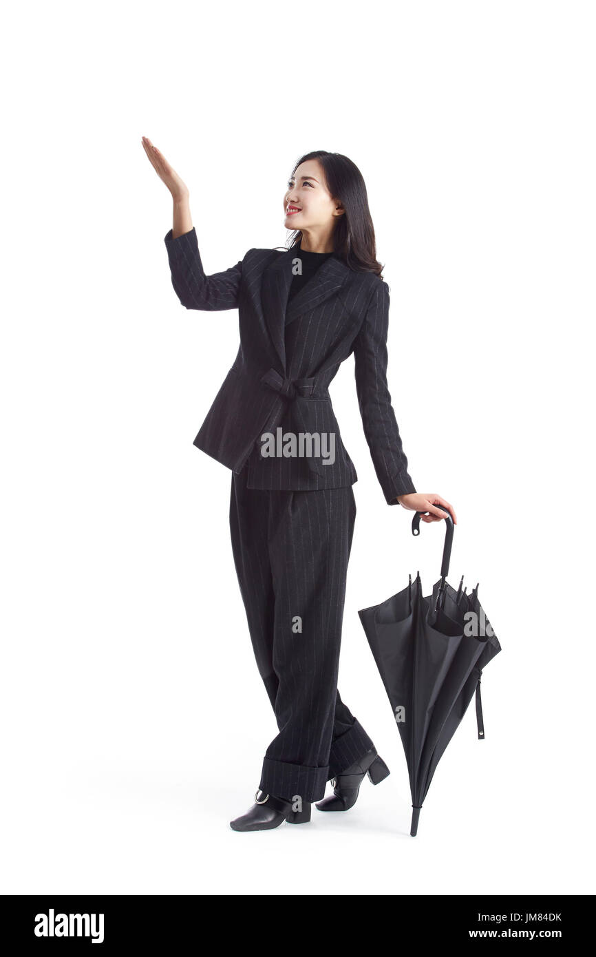 junge asiatische Geschäftsfrau mit gefalteten schwarzen Regenschirm, Studio gedreht, isoliert auf weißem Hintergrund. Stockfoto