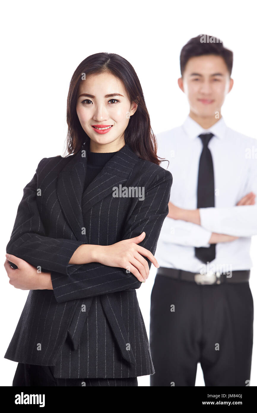 Porträt der jungen asiatischen Geschäftsfrau mit männlichen Kollegen stehen im Hintergrund, Studio gedreht, isoliert auf weiss. Stockfoto