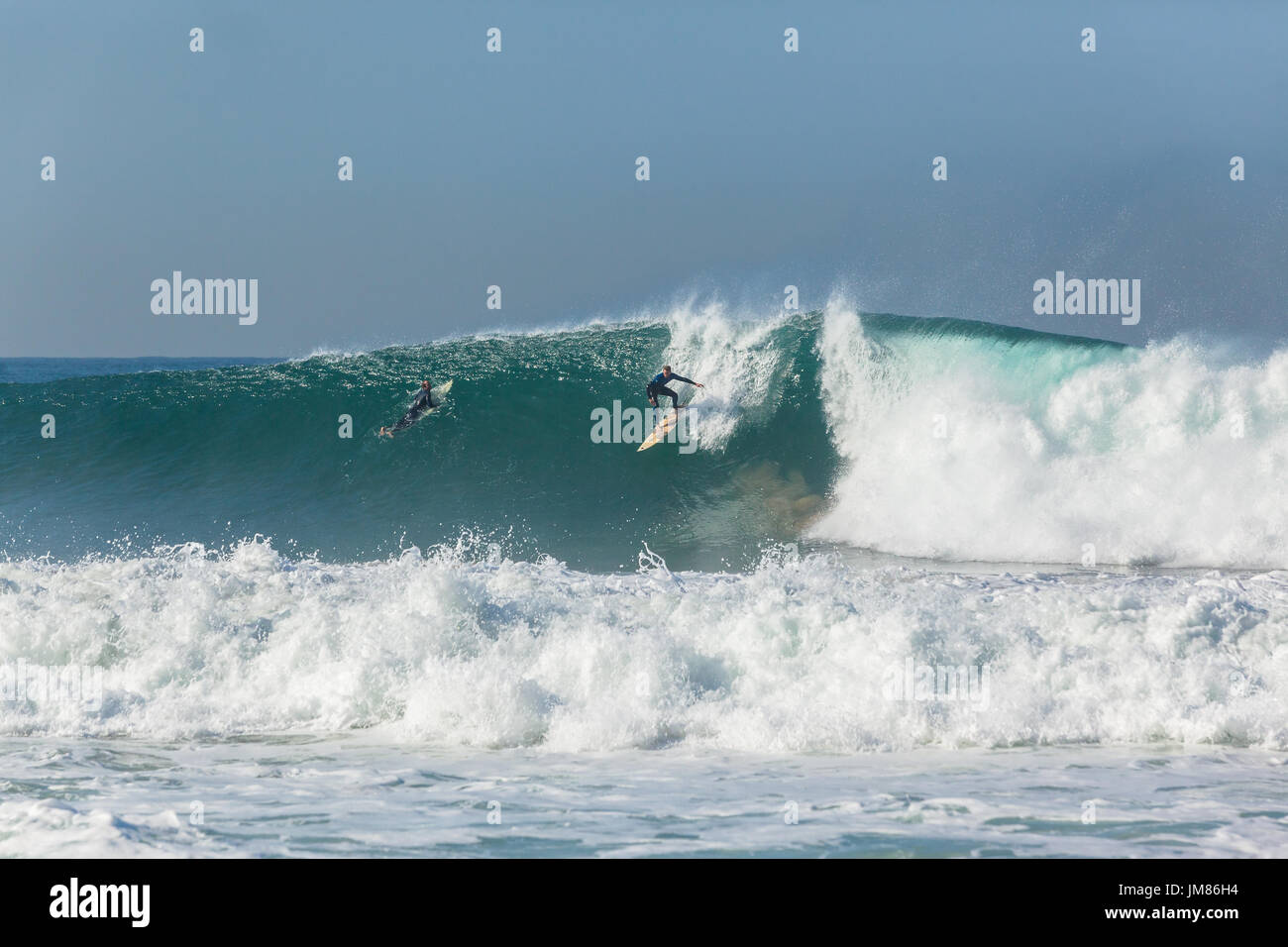 Surfer Surfen ausziehen, um große hohle Ozeanwelle zu reiten. Stockfoto