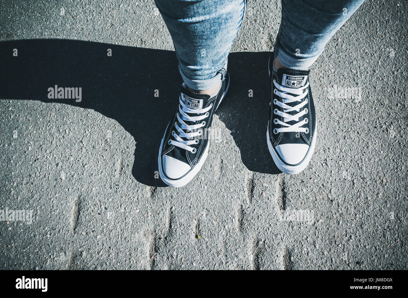 Sankt-Petersburg, Russland-30. Mai 2017: Teenager Füße in einem Paar von schwarzem Canvas Freizeitschuhe Chuck Taylor All-Stars auf städtische Straße stehen Stockfoto