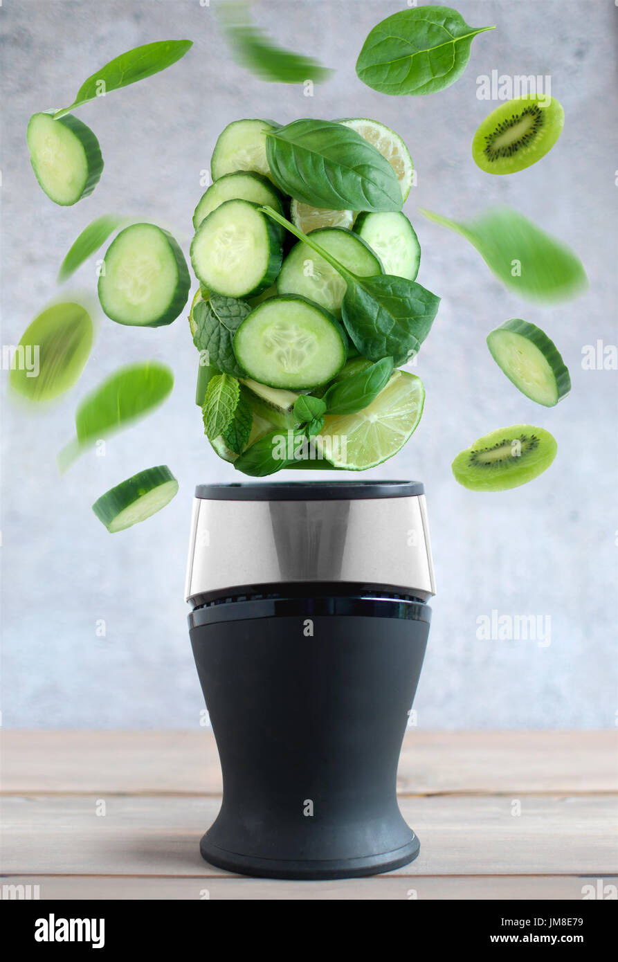 Frische grüne Früchte und Gemüse drehte sich um einen Mixer Konzept Kochen Stockfoto
