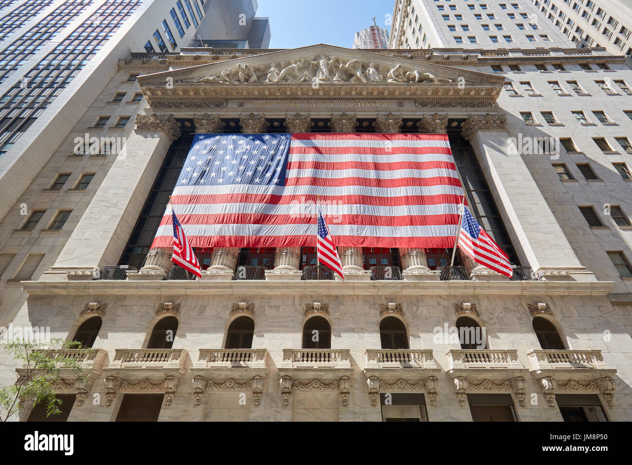 Wall Street Börse Gebäudefassade mit großen US-Flagge, Bankenviertel in New York an einem sonnigen Tag Stockfoto