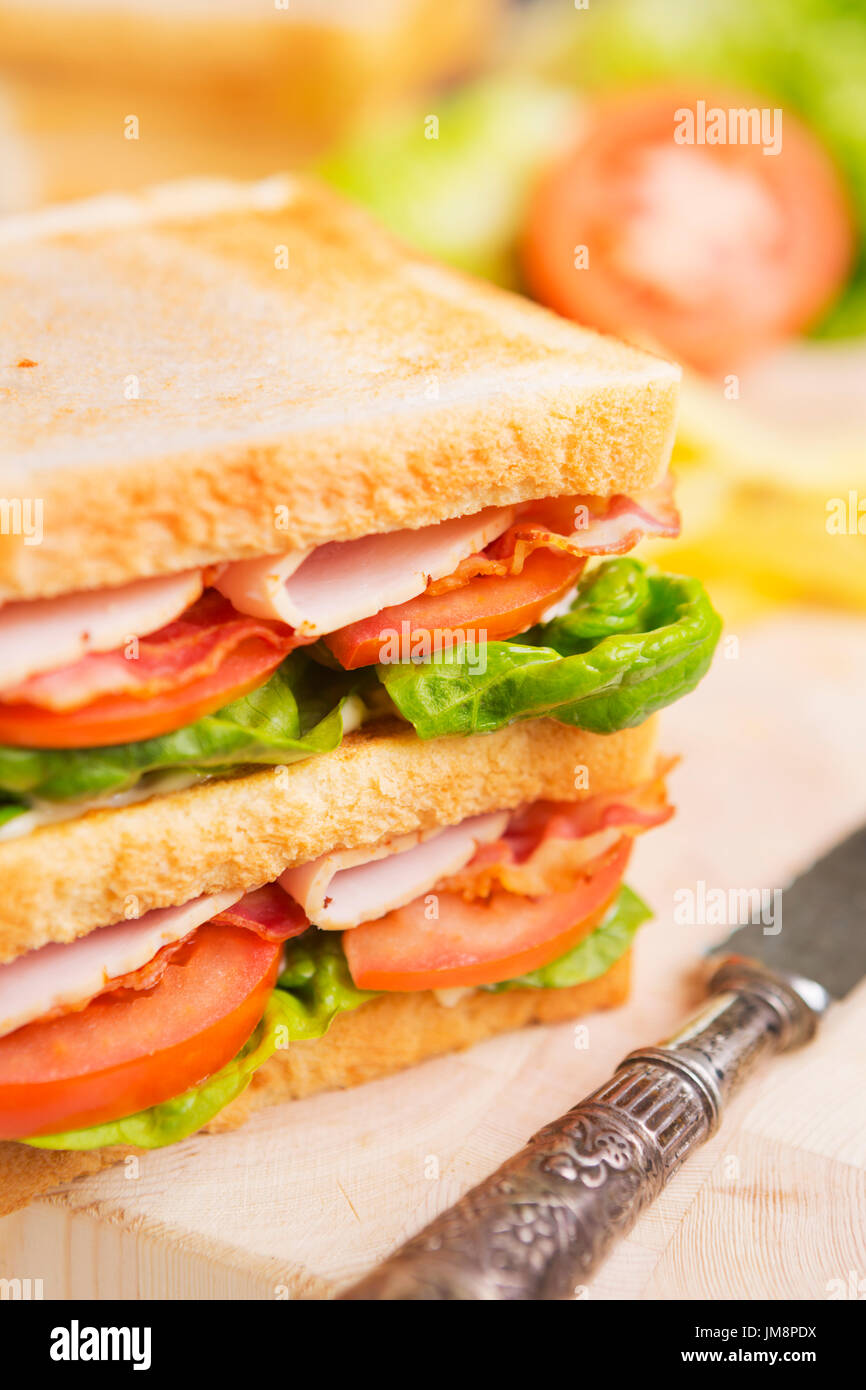 Ein Club-Sandwich auf einem rustikalen Tisch in helles Licht. Stockfoto