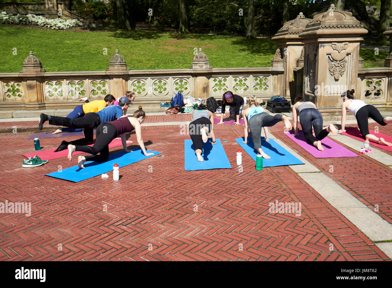 Menschen praktizieren Yoga im Freien in Bethesda Terrasse Central Park New York City, USA Stockfoto