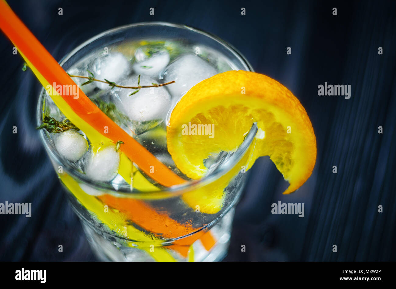 Gin Tonic mit Eis, verziert mit einer Orangenscheibe und Rosmarin. Stockfoto