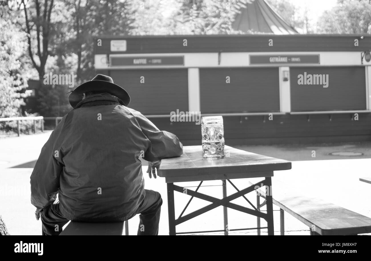 Mann genießt ein Bier im englischen Garten von München. Stockfoto