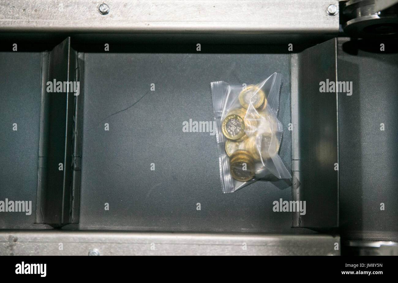 Neue ein Pfund Münzen verpackt und sortiert während eines Besuchs von Fiskus-Sekretärin zum Fiskus, Andrew Jones MP in der G4S Lösungen Liquiditätsfazilität in Newtownabbey in der Nähe von Belfast. Stockfoto