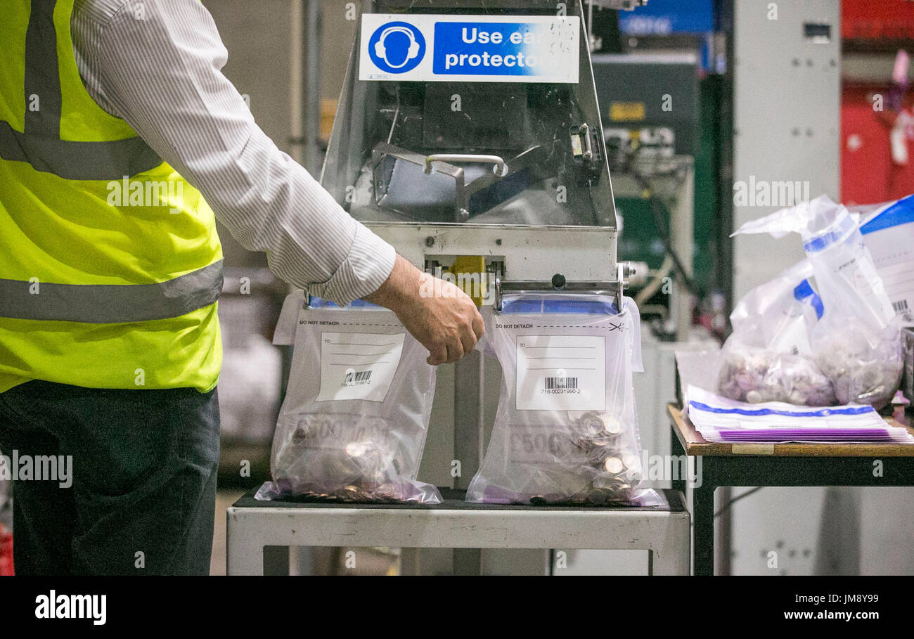 Ein Währung Prozessor unterhält die Sortiermaschine, wie es neue ein Pfund-Münzen bei einem Besuch von Fiskus-Sekretärin zum Fiskus, Andrew Jones MP in der G4S Lösungen Liquiditätsfazilität in Newtownabbey in der Nähe von Belfast Taschen. Stockfoto