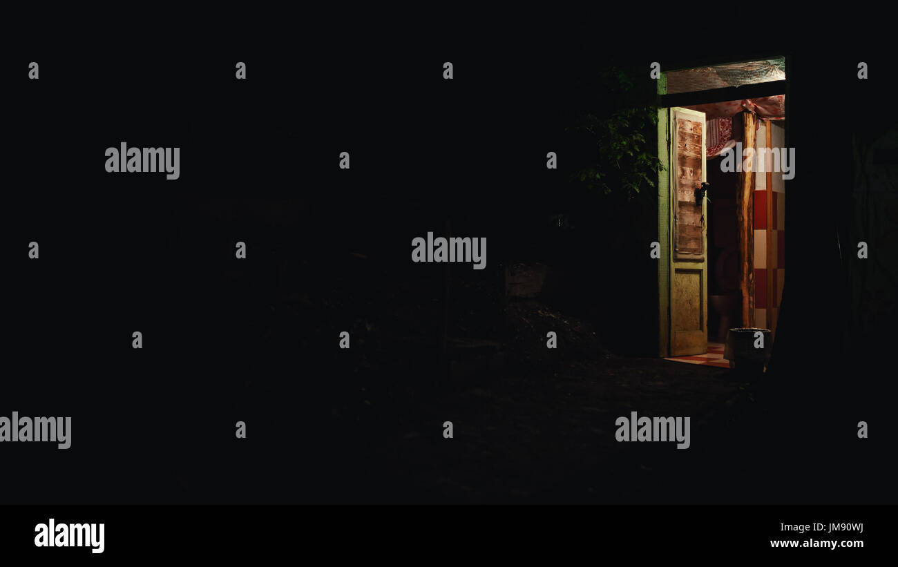Nur ein Eingang eines alten hölzernen Objekts in eine Ecke, dunklen Bereich ringsum. Stockfoto