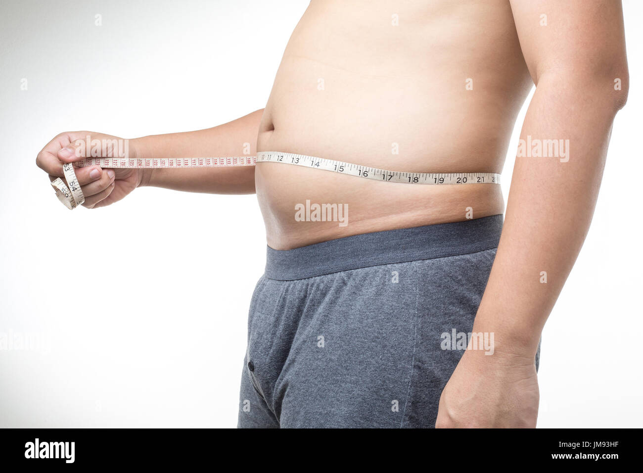 übergewichtiger Mann mit Maßband um die Taille Stockfoto