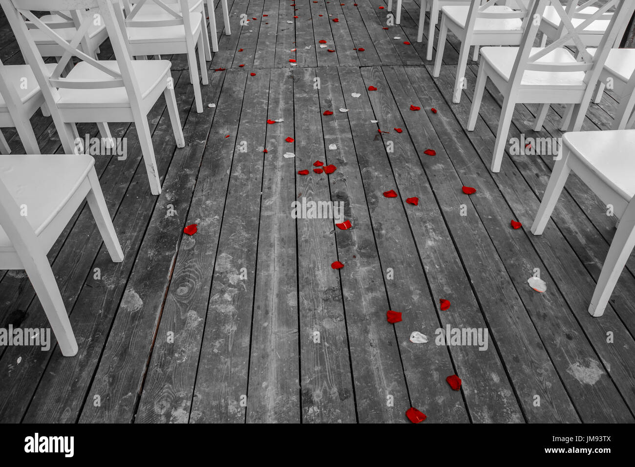 Hochzeit weißen Stühlen Gang mit dem roten Rosenblüten auf dem Holzboden Stockfoto