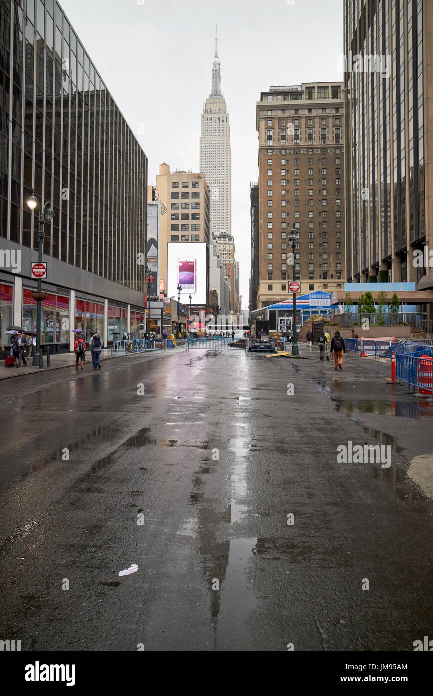 Reflexion der das Empire State building auf nassen Straßen im Regen New York City USA Stockfoto