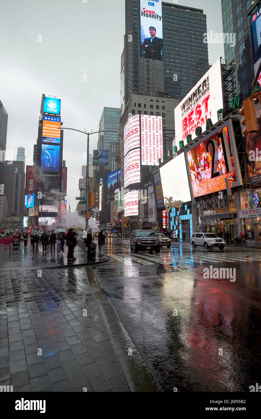 Reflexionen der Bildschirme auf dem Times Square auf Straßen im Regen New York City USA Stockfoto