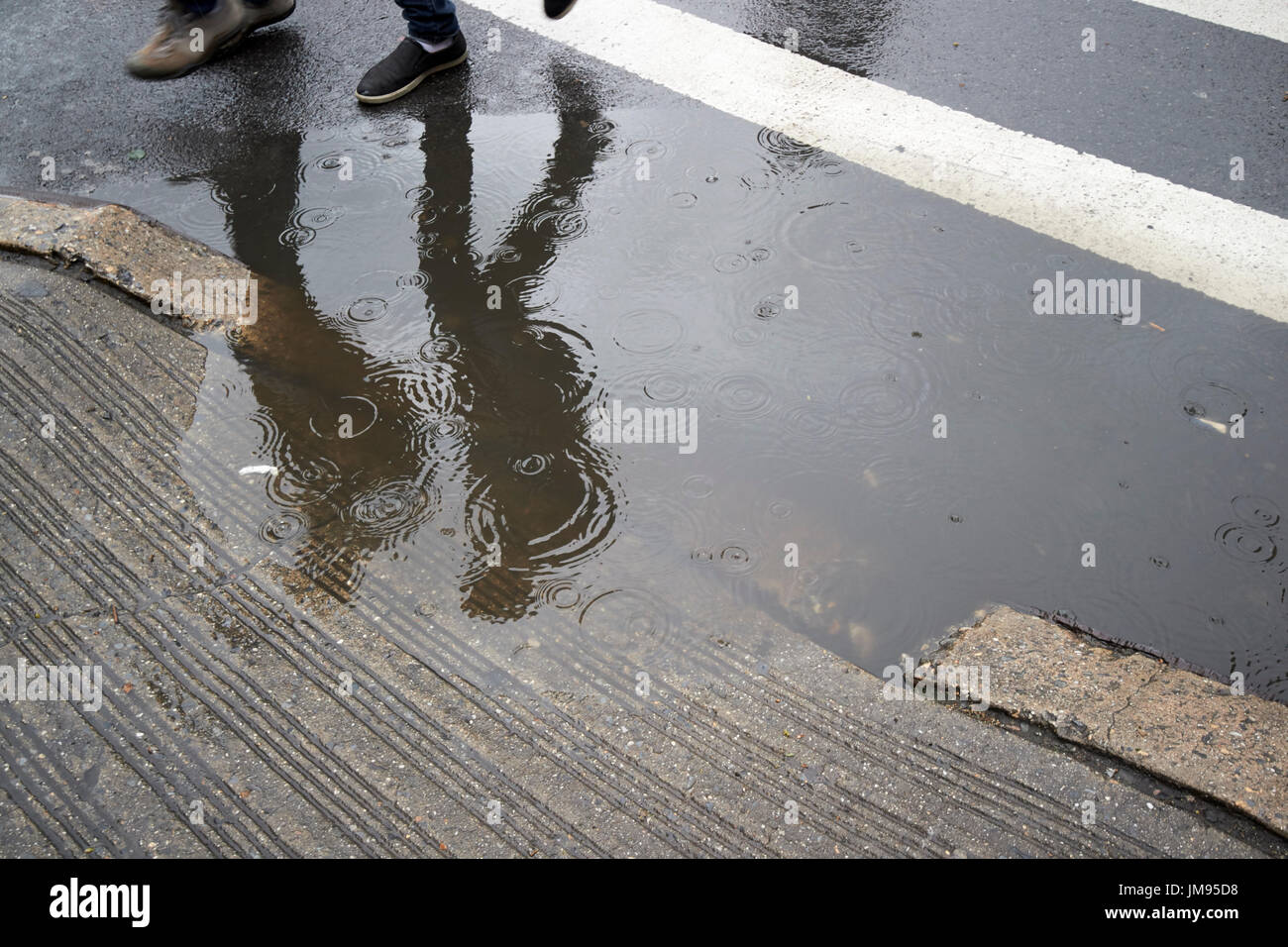 Menschen zu Fuß vorbei an Regenwasser ab, auf den Straßen von New York City USA überschwemmen Stockfoto